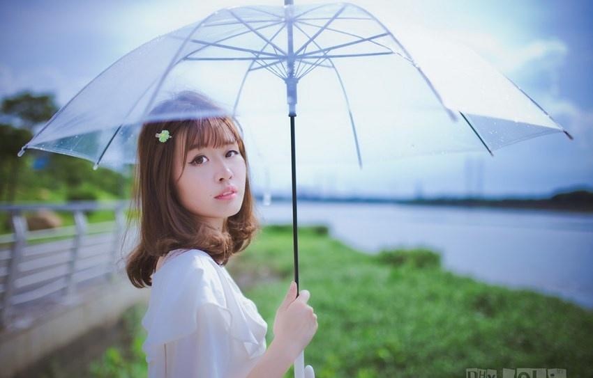夏日头戴小花的清新性感少女撑伞漫步