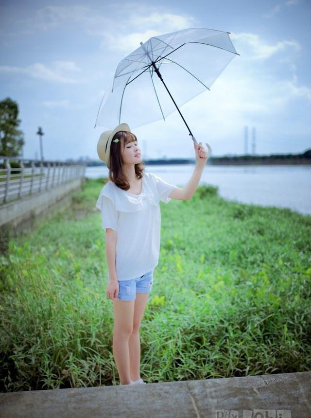夏日头戴小花的清新性感少女撑伞漫步